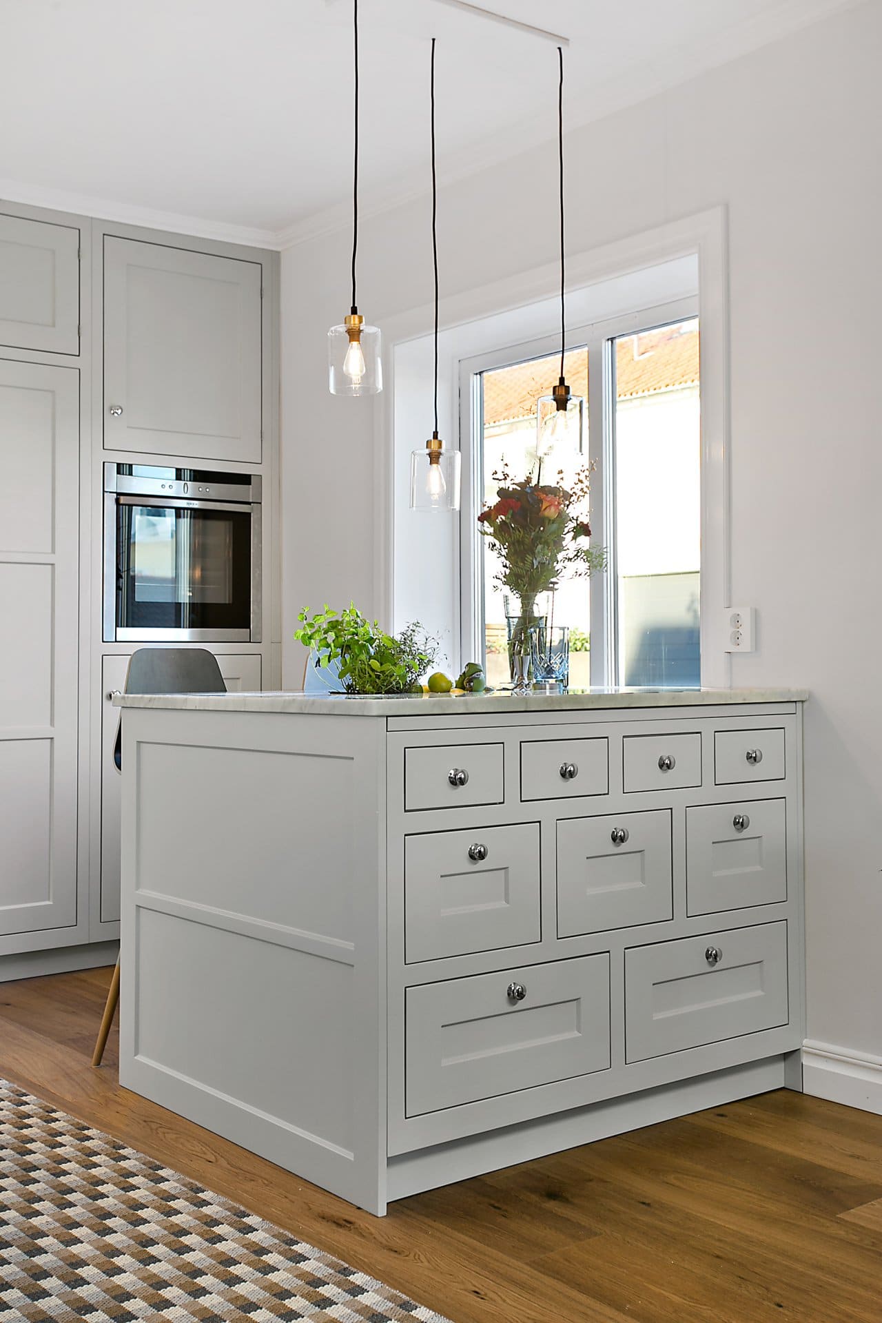 Stiligt - Ett kök med vita skåp och trägolv i klassisk stil.