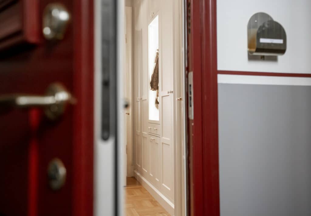 Titta in kika in välkommen in dörröppning entre postfack röd dörr garderob