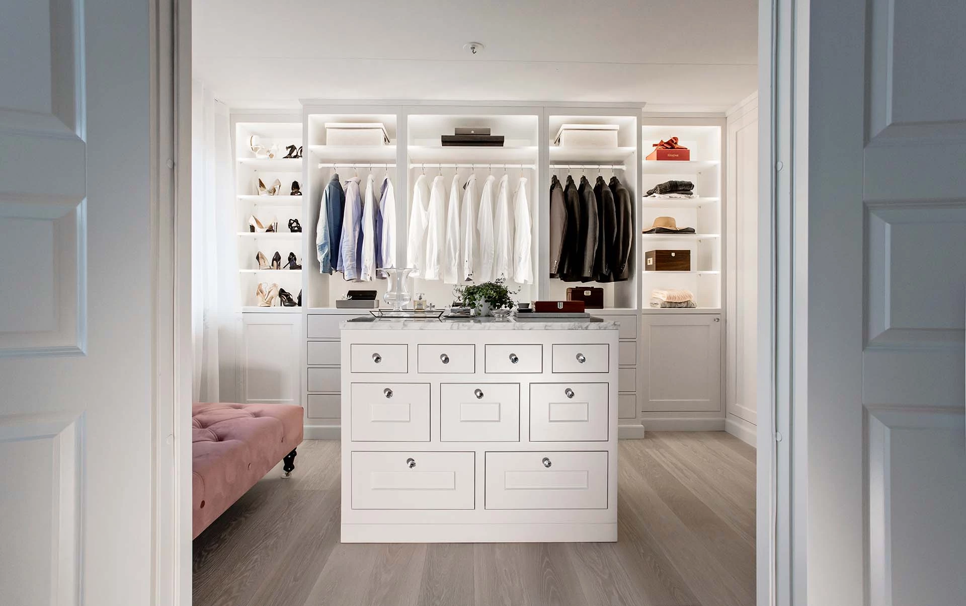 Stiligt - En vit walk in closet med rosa soffa designad av Unika platsbyggda kök & walk in closets.