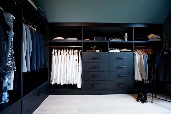 Stiligt - En walk in closet med svarta skåp och lådor till Unika platsbyggda kök & walk in closets.