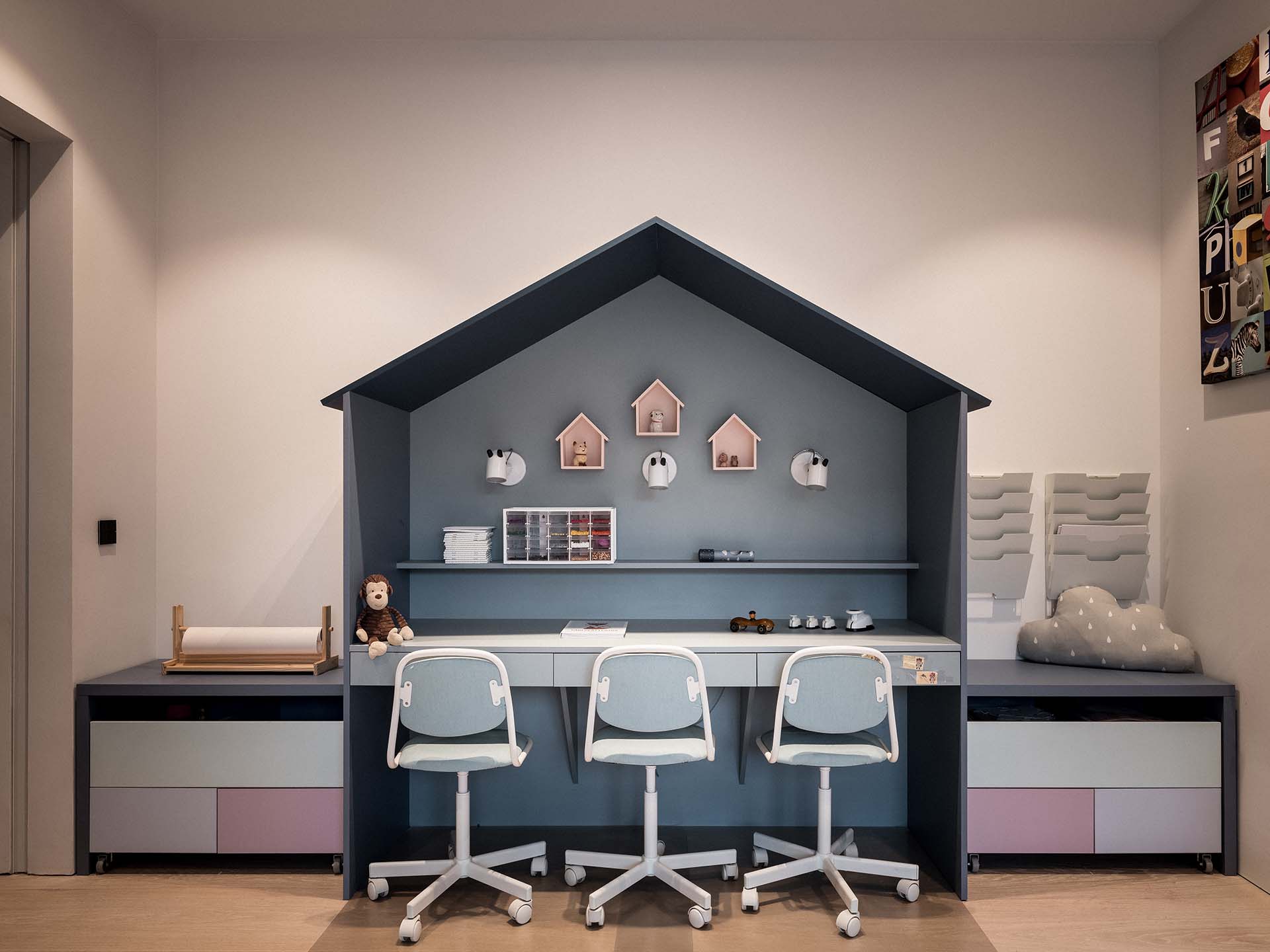 Lekrum med ett platsbyggt hus och skrivbord för barn och leksaksförvaring