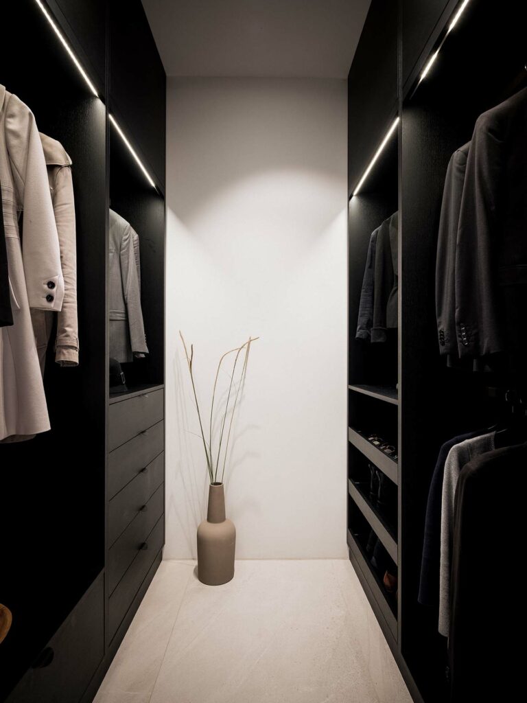 Stiligt - En klädkammare med svarta skåp och en vas är perfekt för förvaring av kläder och accessoarer.