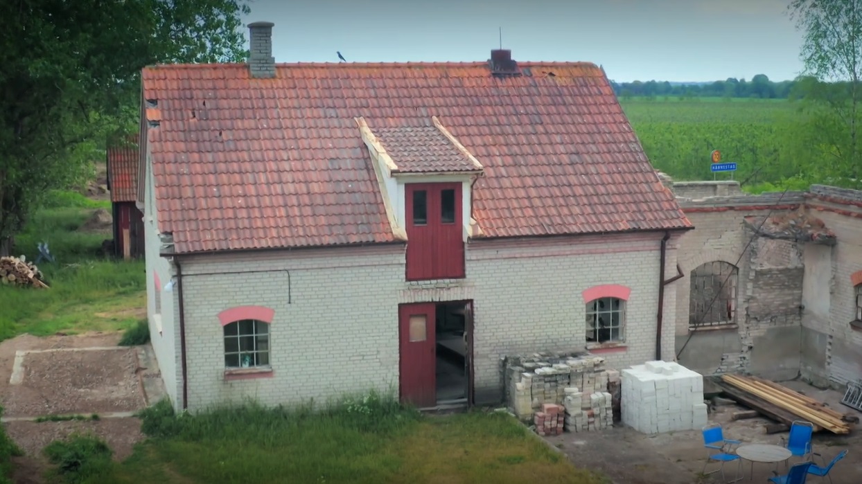 Stiligt - Ett hus med rött tak mitt på en åker nära Drömfabriken i Härnestad.