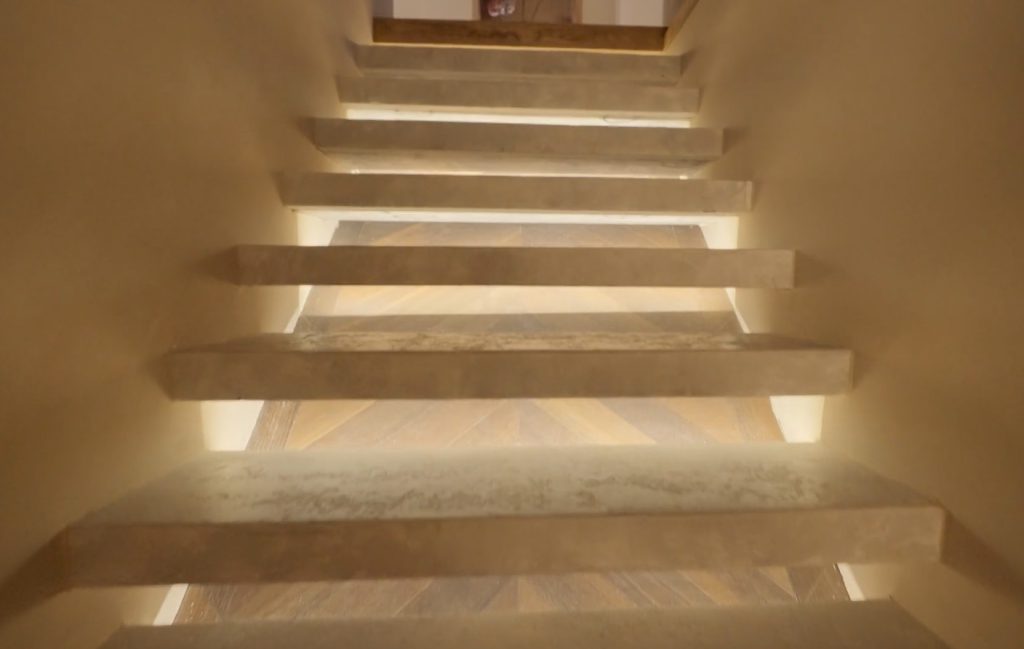 Stiligt - En trappa upplyst av ett ljus från ovan.
