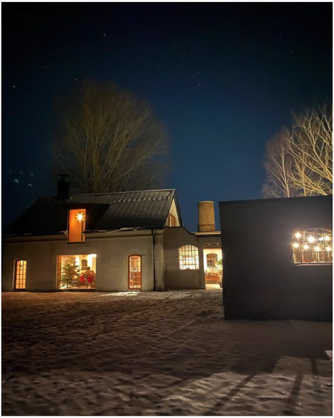 Stiligt - Huset i Härnestad är vackert upplyst på natten, omgivet av snö.