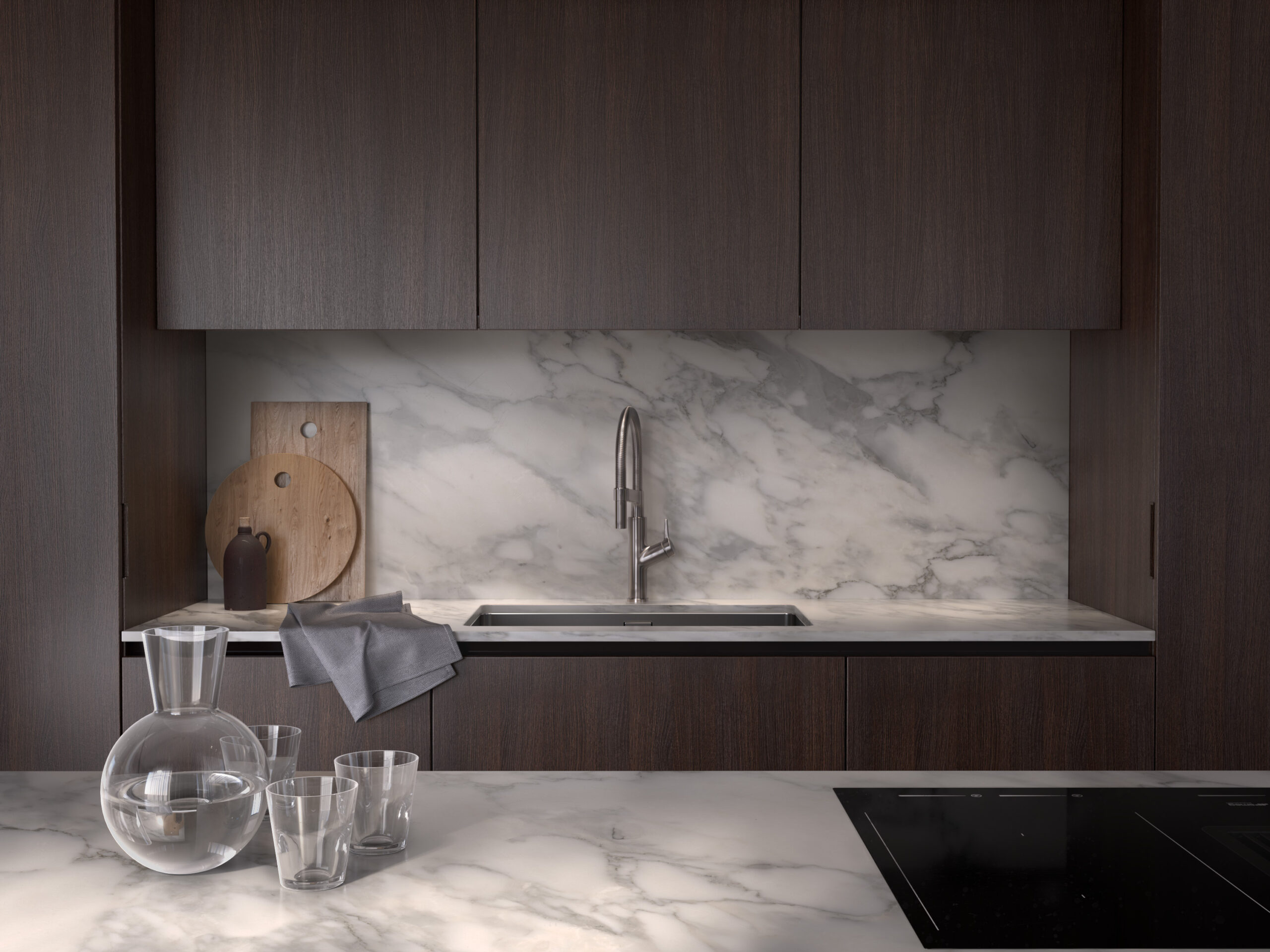 Stiligt - Ett platsbyggt kök med bänkskivor i marmor och träskåp.
