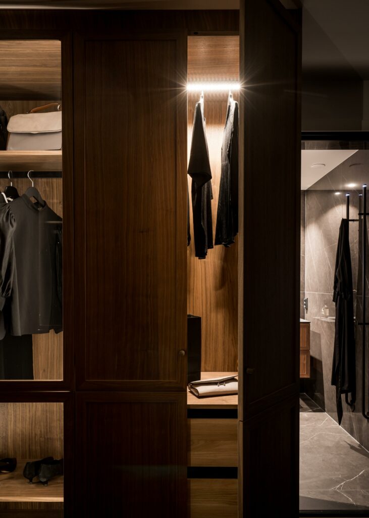 Stiligt - En walk in closet med klassiska kläder hängande i.