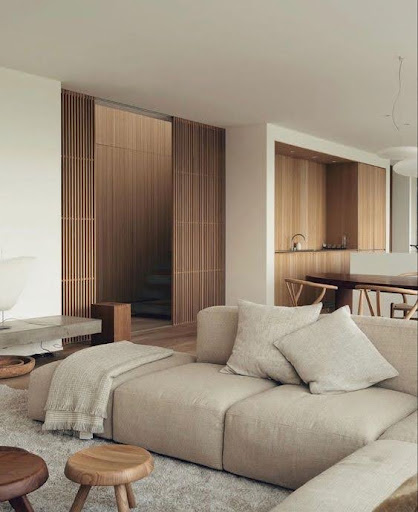 Stiligt - Ett modernt vardagsrum med beiga möbler och träväggar designade inredningsdesign.