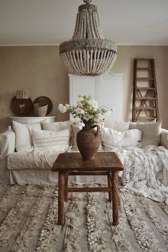 Stiligt - Ett vardagsrum med vita möbler och en ljuskrona inredningsdesign.